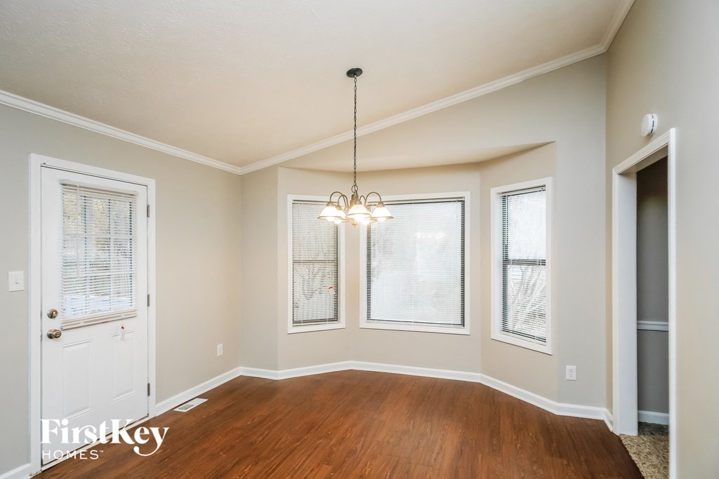 A room with a wooden floor and a chandelier hanging from the ceiling.