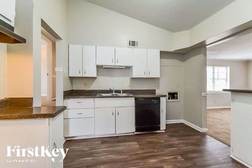 A kitchen with white cabinets and a black oven.
