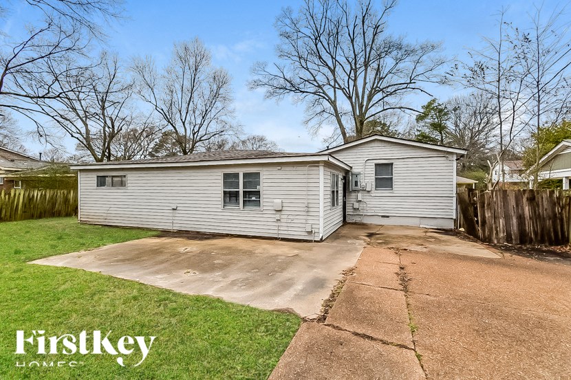 A house with a grey siding and a white roof is for sale.