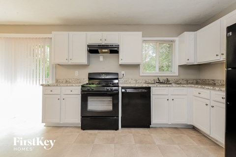 a white kitchen with black appliances and white cabinets