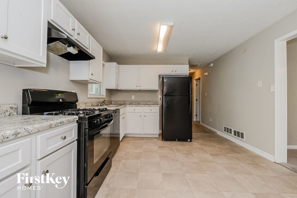 a kitchen with black appliances and white cabinets