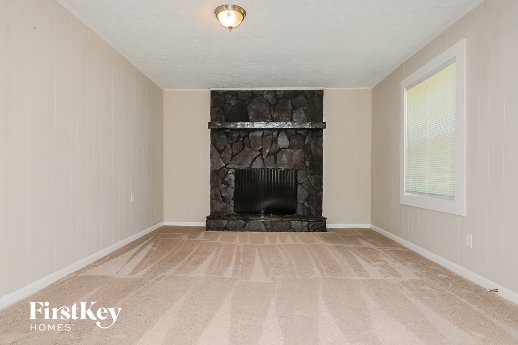 a living room with a fireplace and a carpeted floor
