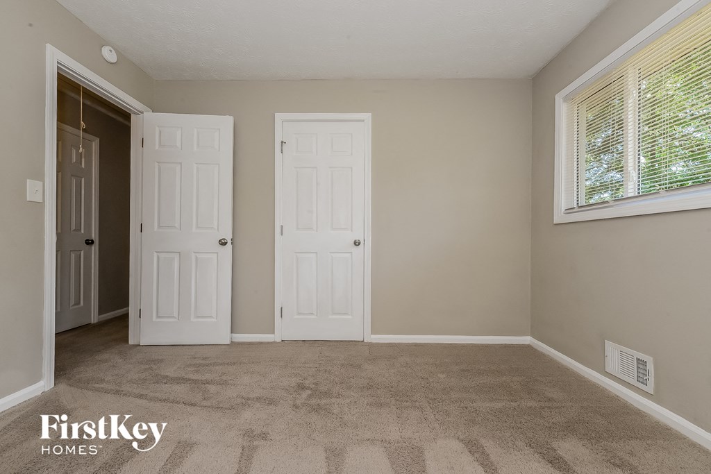 the living room of an empty house with two doors and a window