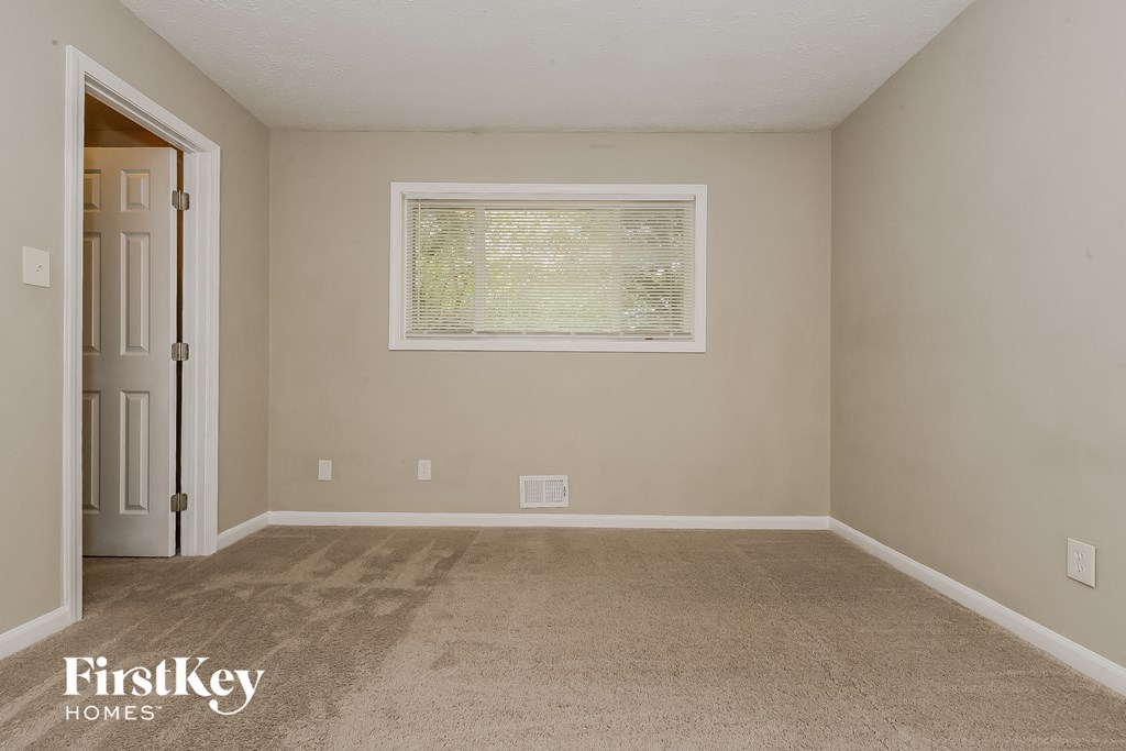 a empty room with carpet and a window