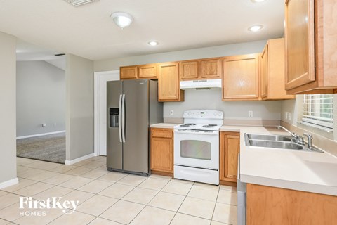 a kitchen with wooden cabinets and white appliances and a stainless steel refrigerator