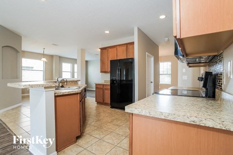 a kitchen with an island and a black refrigerator