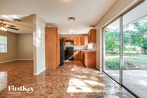 a kitchen with wood cabinets and a sliding glass door