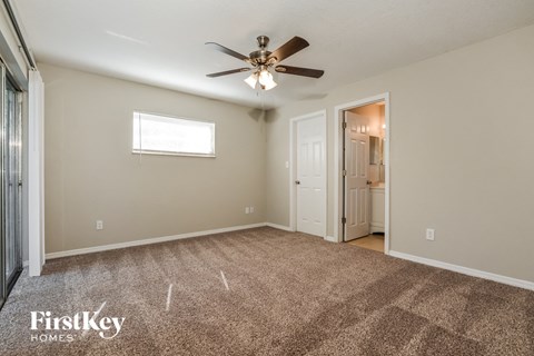 a living room with carpet and a ceiling fan