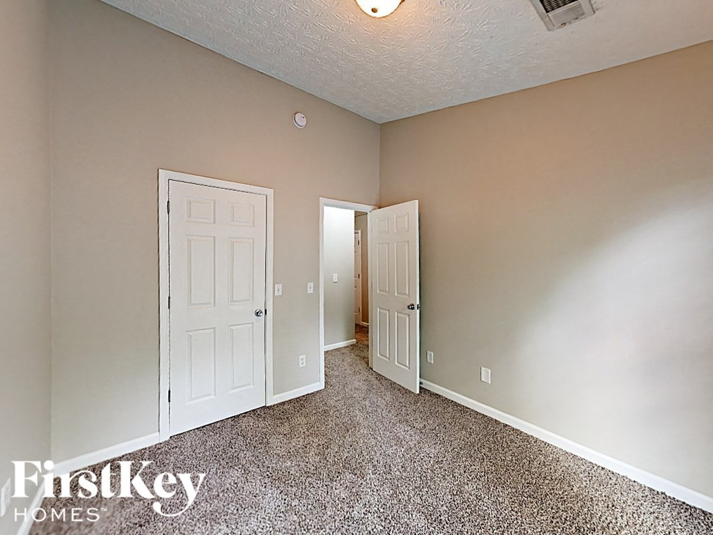 A room with two doors and a carpeted floor.