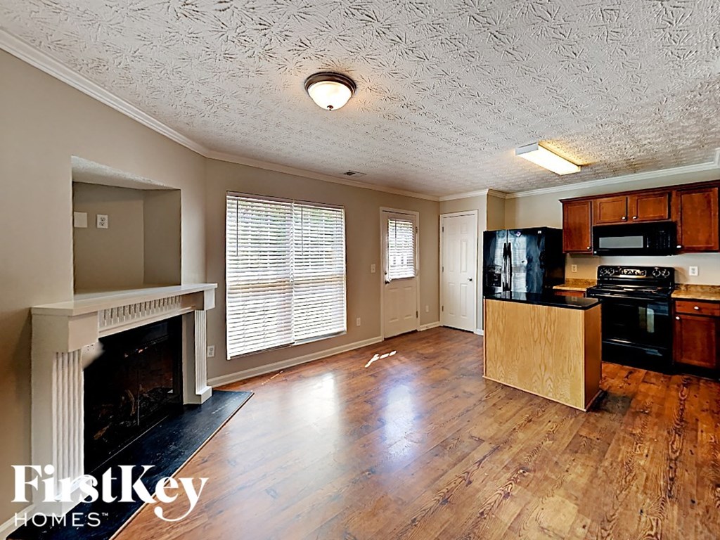 A kitchen with wooden floors and a fireplace.