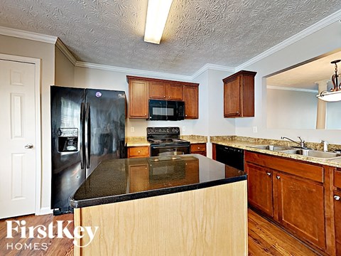 A kitchen with wooden cabinets and a black counter top.