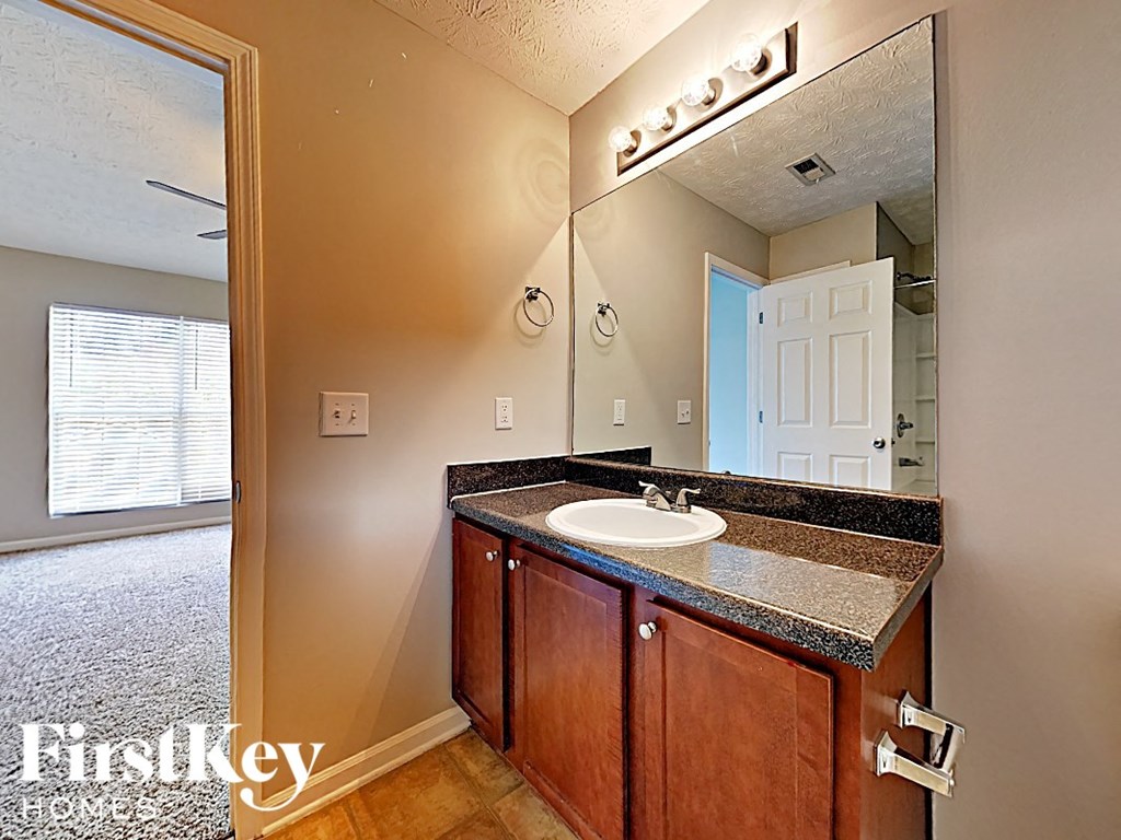 A bathroom with a sink and mirror.