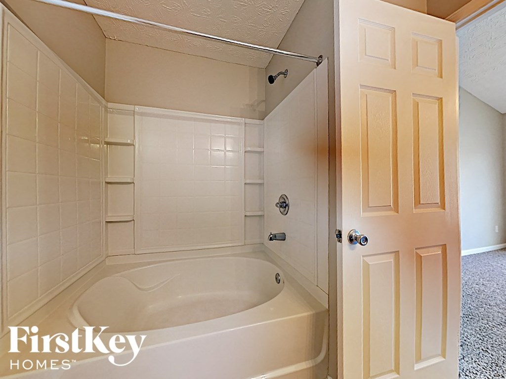 A bathroom with a tub and a door.