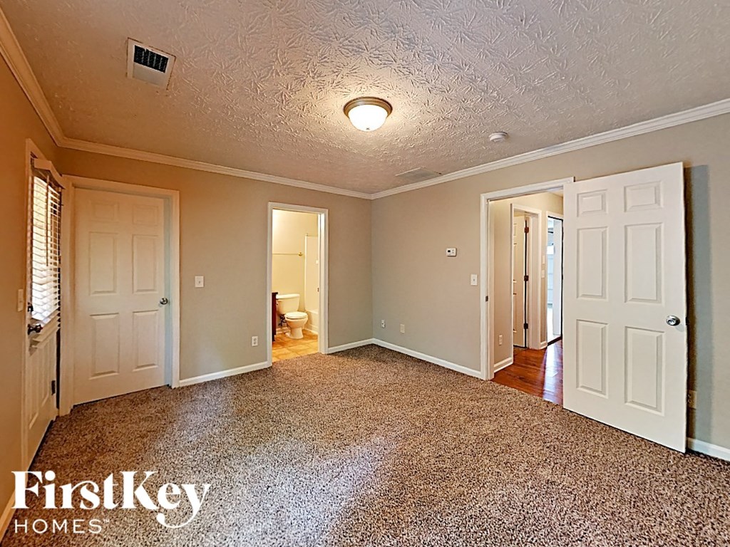 A room with a carpeted floor and a ceiling fan.