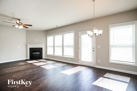 a living room with large windows and a ceiling fan
