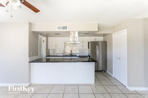 A kitchen with a white counter and a ceiling fan.