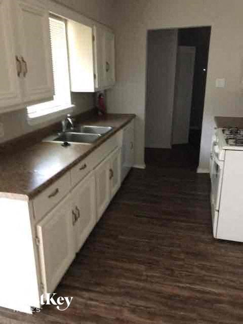 a kitchen with white cabinets and a stove and a sink