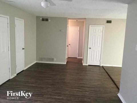 an empty living room with wood floors and white walls