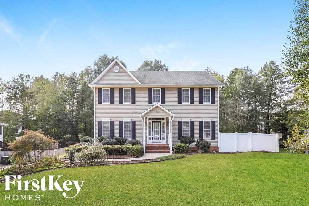 A house with a white picket fence in front.
