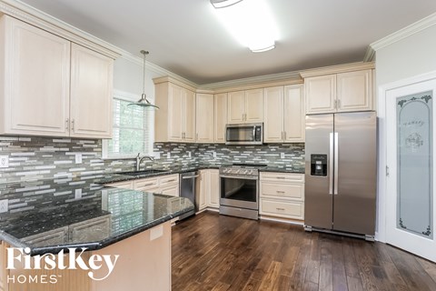 A kitchen with wooden cabinets and a black granite counter top.