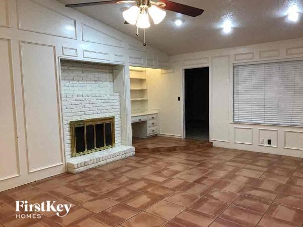 A room with a fireplace and a ceiling fan.