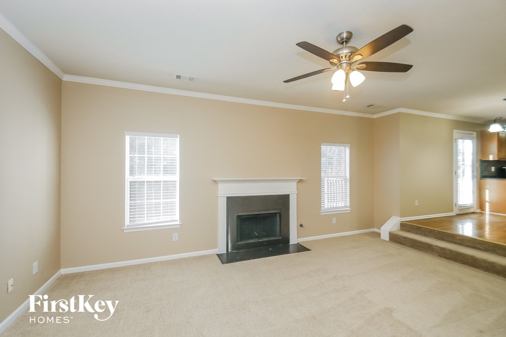 a living room with a fireplace and a ceiling fan