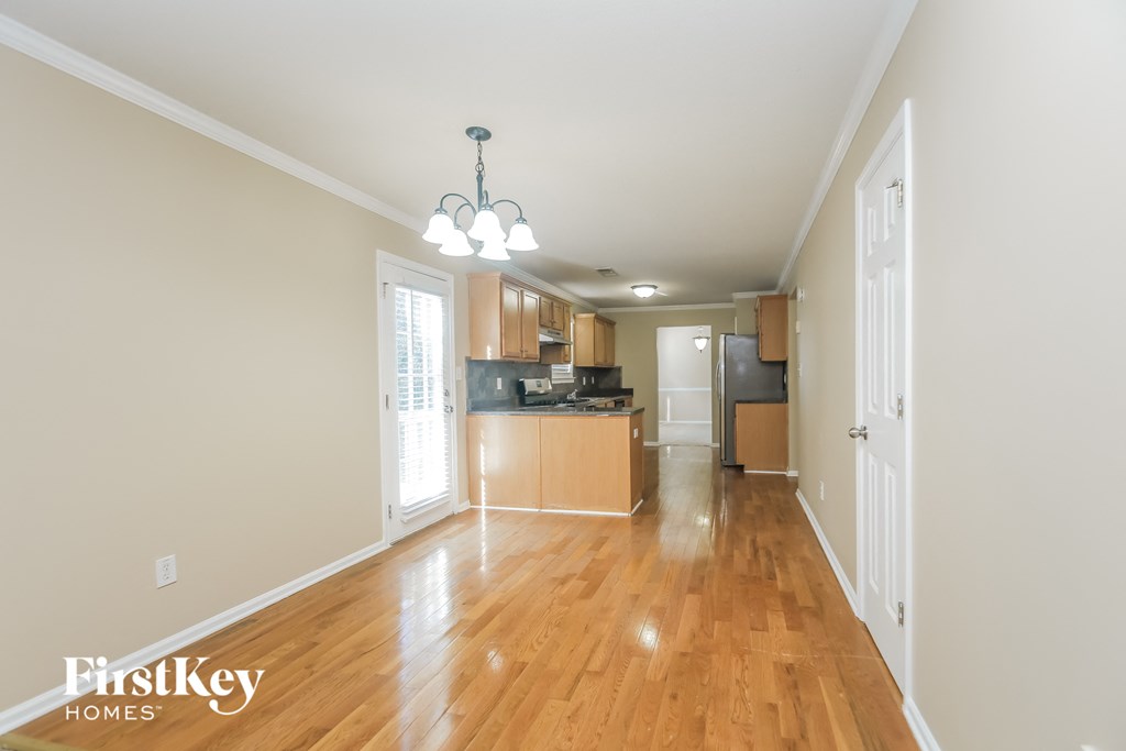 the living room and kitchen of an empty house with wood flooring