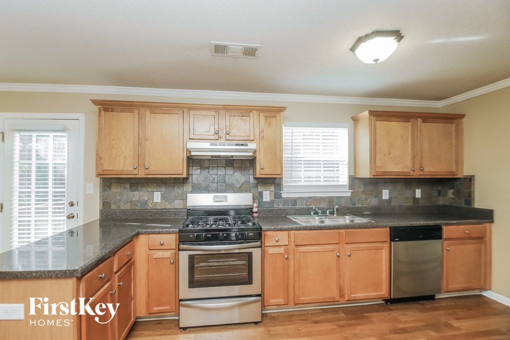 a kitchen with wooden cabinets and a stove and a sink