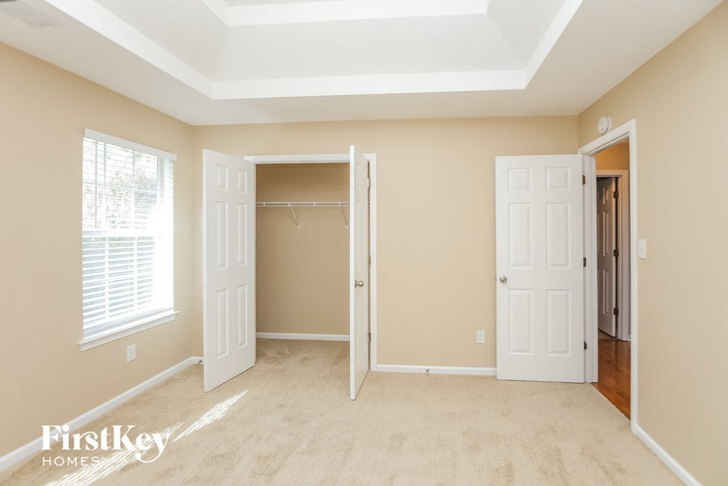an empty bedroom with two doors and a closet