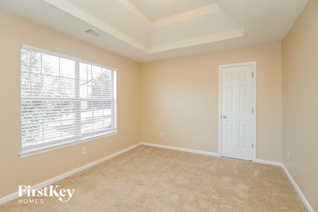 a bedroom with a large window and a white door