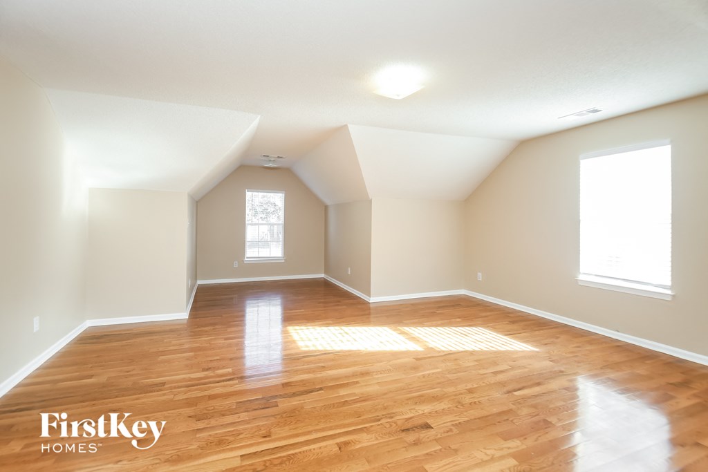 the living room with hardwood floors and white walls