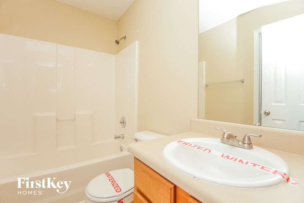 a bathroom with a sink and a tub and a mirror