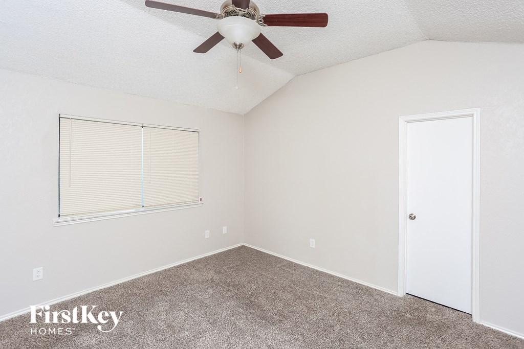 a bedroom with a ceiling fan and a window