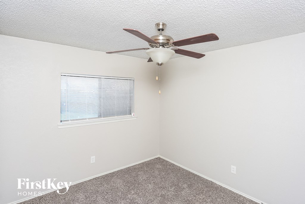a bedroom with a ceiling fan and a window