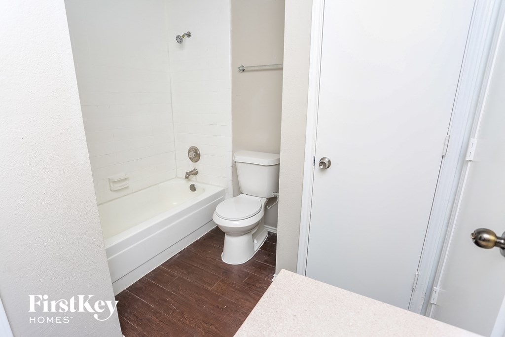 a bathroom with a toilet and a tub and a shower