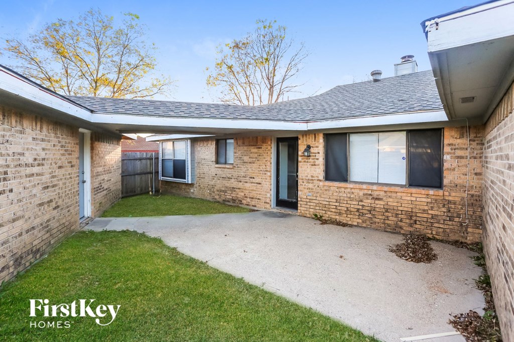 a small yard in front of a brick house