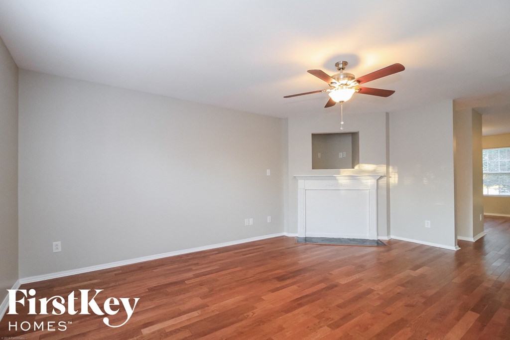 A room with a wooden floor and a ceiling fan.