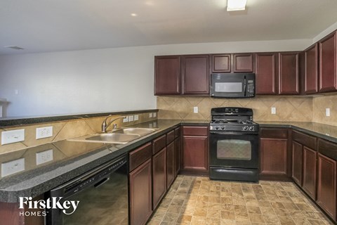 a kitchen with wood cabinets and a stove and a sink