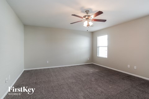 a living room with carpet and a ceiling fan