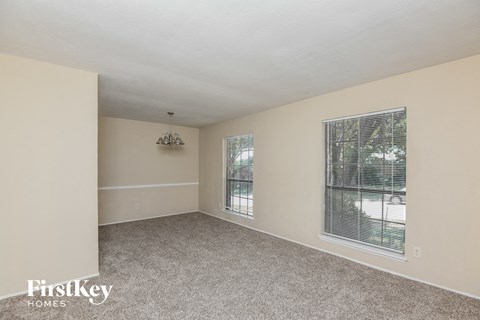 a spacious living room with carpet and a large window