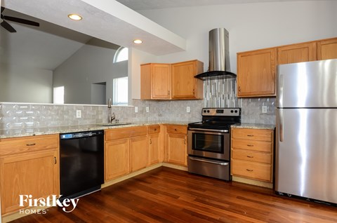 A kitchen with wooden cabinets and a stainless steel refrigerator.