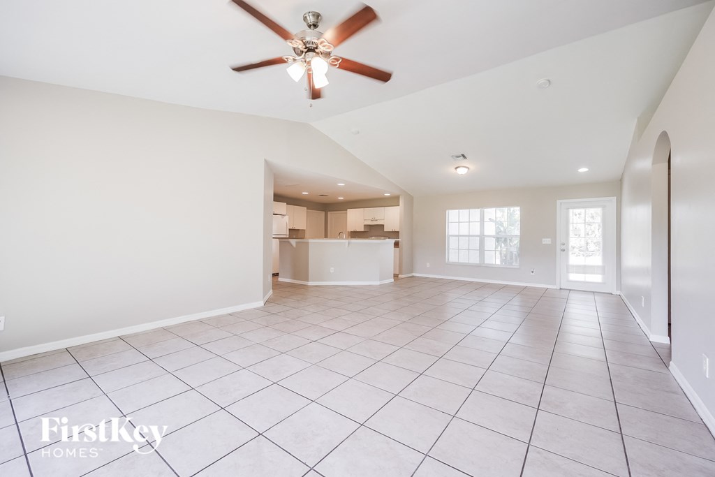 an empty kitchen and living room with a ceiling fan