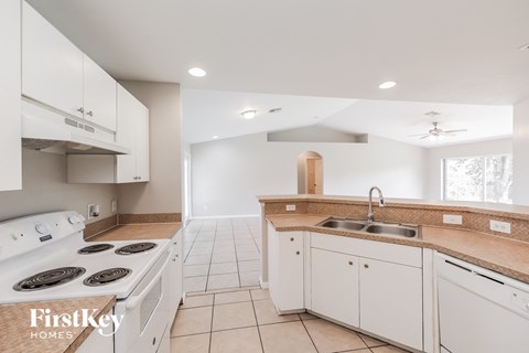 a kitchen with white cabinets and a stove and a sink