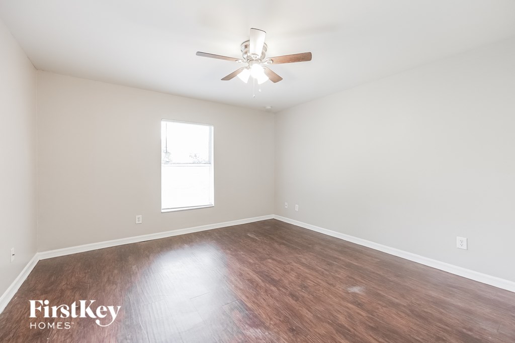 a living room with wood flooring and a ceiling fan