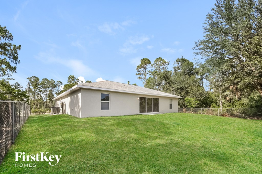 a small white house sitting on top of a lush green field