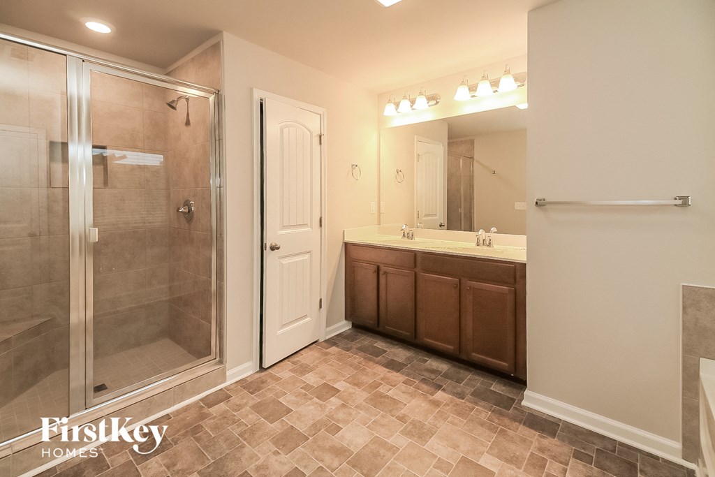 a bathroom with a shower and a sink and a mirror