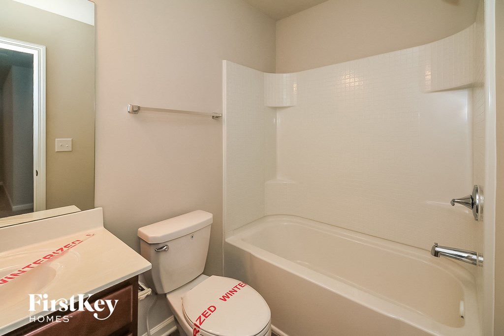 a bathroom with a white toilet and a tub and a sink