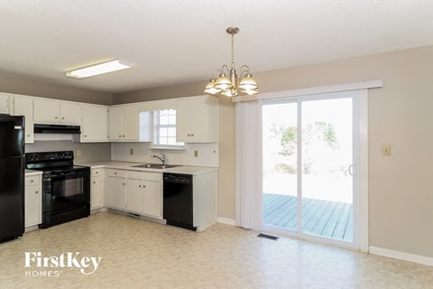 A kitchen with black appliances and white cabinets.