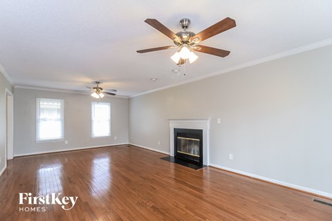 a living room with a fireplace and a ceiling fan