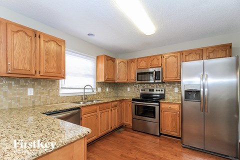 a kitchen with wooden cabinets and stainless steel appliances